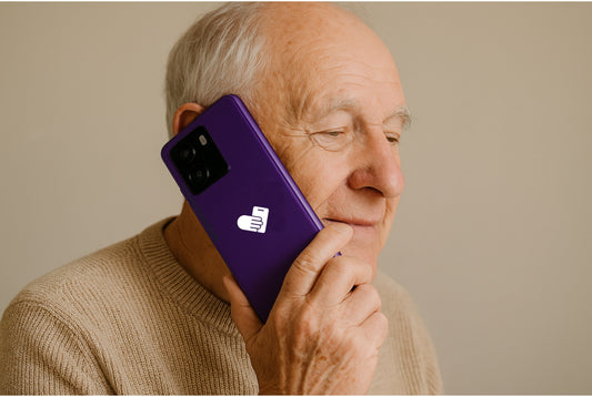 man holding a seniors mobile the bigpurplephone and using it for a call